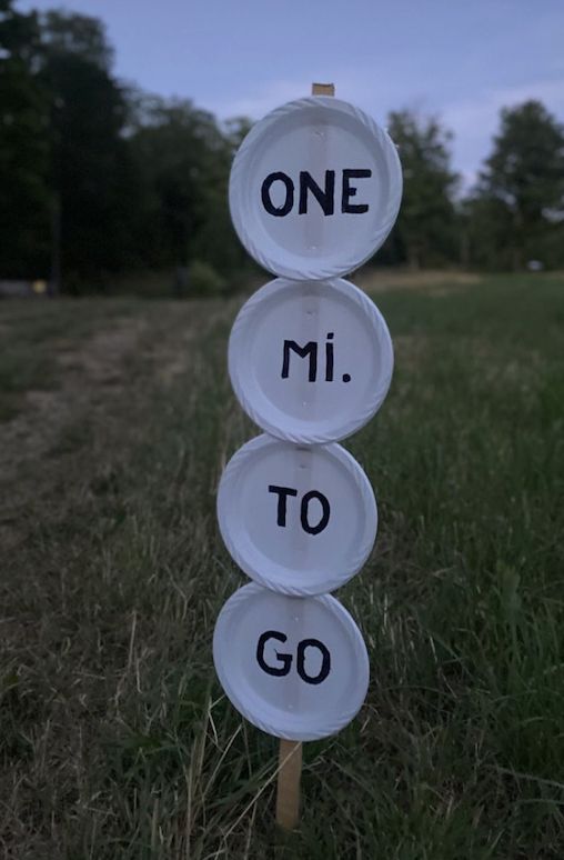 plates on a stake that spells out 1 mile to go